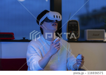 ヴァーチャルリアリティ　ハンドコントローラーを持ちVRゴーグルをした若い男性 116936571