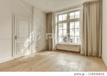 Interior of empty living room with large bright window and curtains by closed door in modern apartment with white walls and hardwood floor 116936628