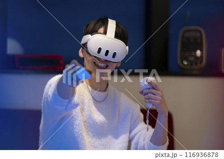ヴァーチャルリアリティ ハンドコントローラーを持ちVRゴーグルを装着した若い男性 ヴァーチャルリアリティ ハンドコントローラーを持ちVRゴーグルを装着した若い男性 116936878