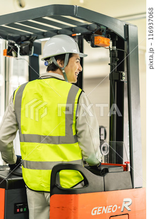 フォークリフトを運転する笑顔の30代男性作業員 フォークリフトを運転する笑顔の30代男性作業員 116937068