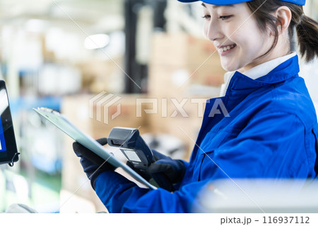 片手にスキャナーを持った物流倉庫で働く女性作業員 片手にスキャナーを持った物流倉庫で働く女性作業員 116937112