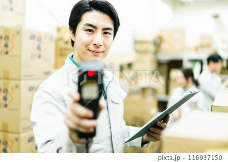 端末で入出庫管理する男性管理者 116937150