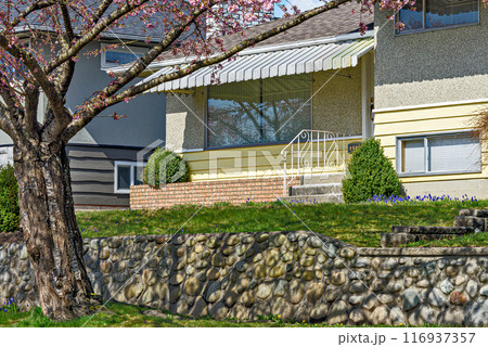 Entrance of the family house under the canopy with front lawn on the land terrace Entrance of the family house under the canopy with front lawn on the land terrace 116937357