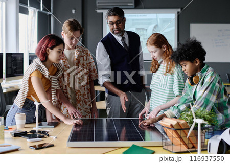 Medium long shot of teacher of Environmental Education speaking about solar energy and PV modules during lesson 116937550