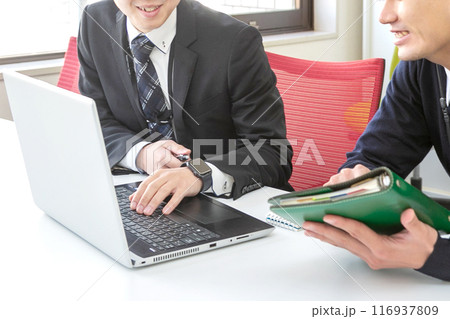 PCを見ながら企画をするビジネスマン 116937809