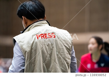 Backside of Asian Press man captures Sports news in Sports Stadium. 116938052