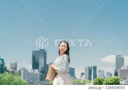 青空とビル群を背景にしたビジネスウーマン 青空とビル群を背景にしたビジネスウーマン 116939033