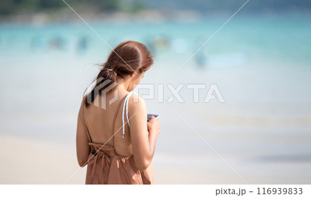 The shoulder of Asian Thai Woman from backside who play mobile at outdoor field sea beach blur background. The shoulder of Asian Thai Woman from backside who play mobile at outdoor field sea beach blur background. 116939833