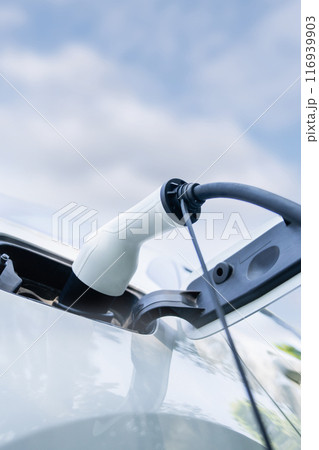 Close up of electric car inlet with a connected charging cable Close up of electric car inlet with a connected charging cable 116939903