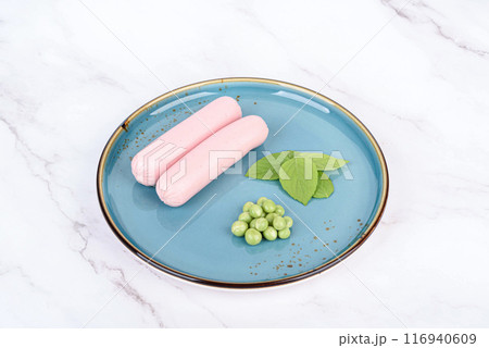 Breakfast with boiled sausages, green peas and basil leaves. 116940609