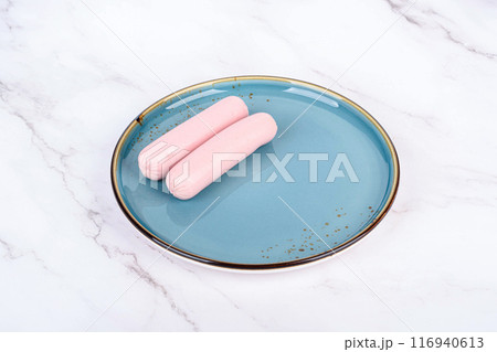 Boiled sausages on a blue plate with reflection. 116940613