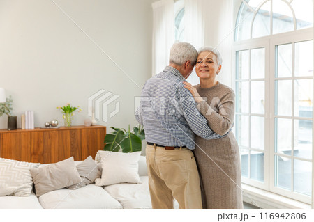 Keep moving. Romantic senior mature couple dancing to music together at home. Happy smiling family retired man woman husband wife having fun enjoying time together. Family moment love care Keep moving. Romantic senior mature couple dancing to music together at home. Happy smiling family retired man woman husband wife having fun enjoying time together. Family moment love care 116942806