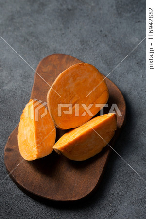 Large sweet potato with an orange center on a wooden board Large sweet potato with an orange center on a wooden board 116942882