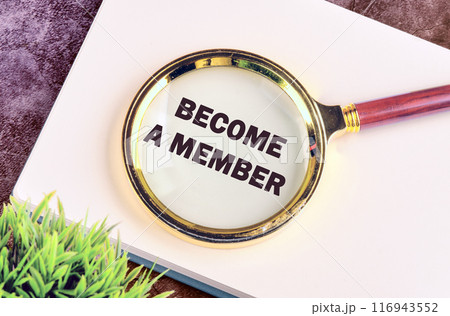 Business and education concept. Text BECOME A MEMBER through a magnifying glass in a business book, top view, conceptual photo Business and education concept. Text BECOME A MEMBER through a magnifying glass in a business book, top view, conceptual photo 116943552