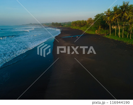 Drone view of black sand coastline with ocean waves on Keramas beach, Bali Drone view of black sand coastline with ocean waves on Keramas beach, Bali 116944190