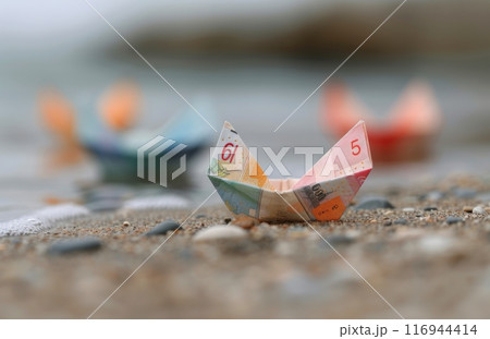 Paper Boat Made From Twenty Dollar Bill on Beach Paper Boat Made From Twenty Dollar Bill on Beach 116944414