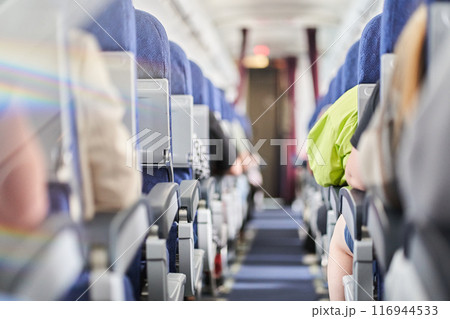 The rainbow light selectively focuses on the narrow aisle in the cabin along the seats. Daylight in the airline cabin. There is a place to copy. High quality photo 116944533