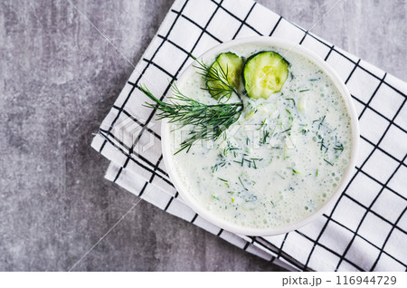 Close up of tzatziki sauce with cucumber, garlic and dill on kefir in a bowl on the table top view Close up of tzatziki sauce with cucumber, garlic and dill on kefir in a bowl on the table top view 116944729