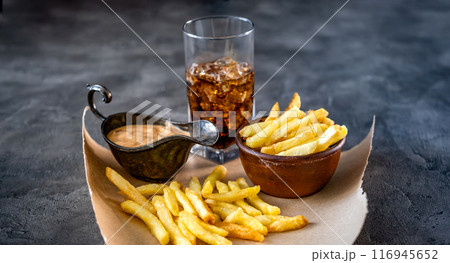 Tasty french fries with drink and sauce 116945652