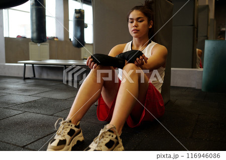 Young tired sportswoman in modern gym 116946086