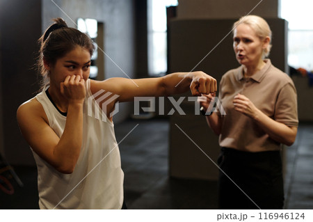 Young female boxer with clenched fists 116946124