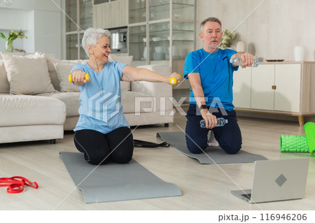 Fitness workout training. Senior adult mature healthy fit couple doing sports exercise on yoga mat on floor at home. Mid age old husband wife have training workout. Health care healthy lifestyle Fitness workout training. Senior adult mature healthy fit couple doing sports exercise on yoga mat on floor at home. Mid age old husband wife have training workout. Health care healthy lifestyle 116946206