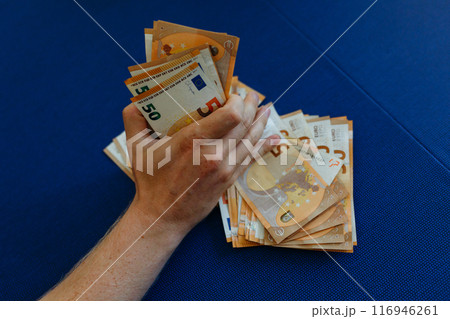 close-up view of man hand holding a pile of money 116946261