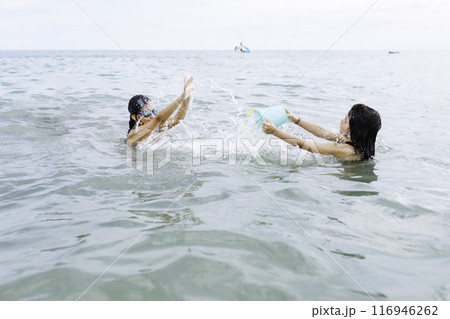 two playing playing with water standing in the sea 116946262