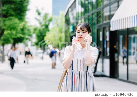 猛暑に耐えペットボトルで体を冷やす若い女性 猛暑に耐えペットボトルで体を冷やす若い女性 116946436
