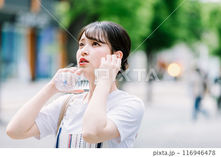 猛暑に耐えペットボトルで体を冷やす若い女性 116946478