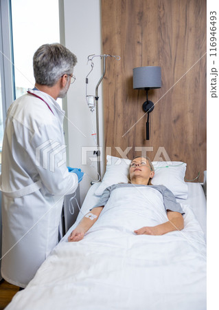 Male doctor examining a patient in an intensive therapy department Male doctor examining a patient in an intensive therapy department 116946493