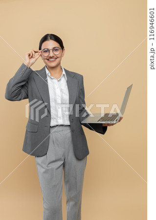 Smiling woman in formal wear using laptop for office work 116946601