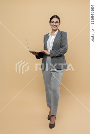 Attractive happy woman in formal wear using laptop for remote work 116946604