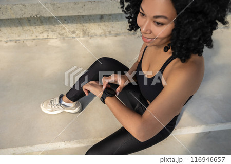 Top view of a smiling pretty woman in sportswear checking her pulsometer 116946657