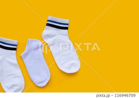 White socks on yellow background. White socks on yellow background. 116946709