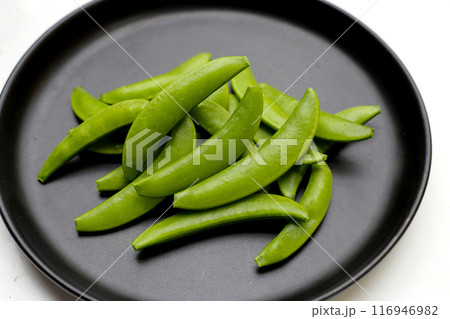 Fresh young green peas on dark plate Fresh young green peas on dark plate 116946982