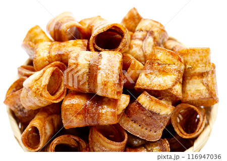 Dried banana rolled chips on white. 116947036