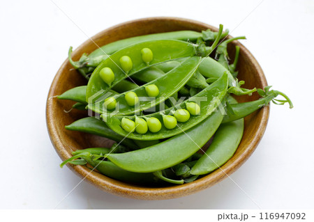 Fresh young green peas on white background. Fresh young green peas on white background. 116947092