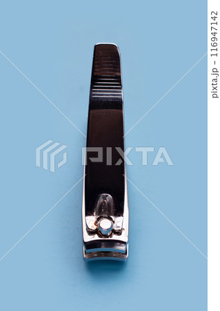 Nail clippers on blue background. 116947142