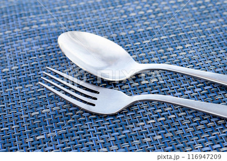Spoon and fork on place mat Spoon and fork on place mat 116947209