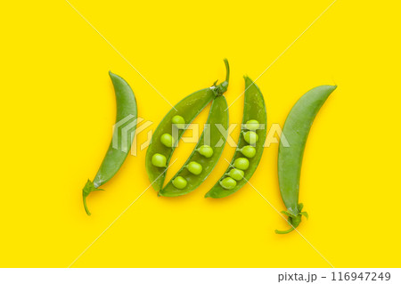 Fresh young green peas on yellow background. 116947249