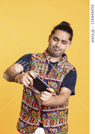 Happy man relaxing playing videogames on cellphone in landscape mode, enjoying leisure time. Cheerful player enjoying game on mobile phone, having fun, isolated over studio background Happy man relaxing playing videogames on cellphone in landscape mode, enjoying leisure time. Cheerful player enjoying game on mobile phone, having fun, isolated over studio background 116948459