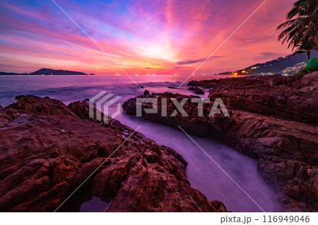 Long exposure image of Dramatic sky seascape with rocks and waves crashing on seashore in sunset or sunrise scenery background Long exposure image of Dramatic sky seascape with rocks and waves crashing on seashore in sunset or sunrise scenery background 116949046