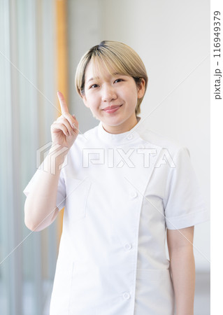 ケーシー白衣を着る金髪ショートヘアの若い女性整体師（髪色自由、自分らしく働く、職場環境） 116949379