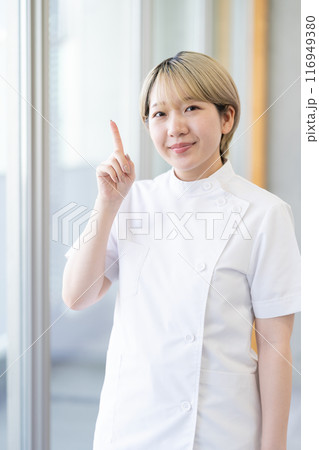 ケーシー白衣を着る金髪ショートヘアの若い女性整体師（髪色自由、自分らしく働く、職場環境） 116949380
