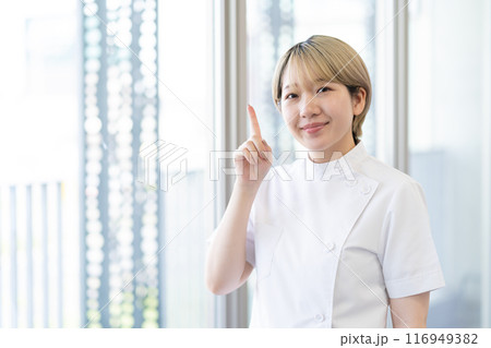 ケーシー白衣を着る金髪ショートヘアの若い女性整体師（髪色自由、自分らしく働く、職場環境） 116949382