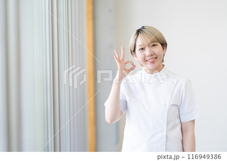 ケーシー白衣を着る金髪ショートヘアの若い女性整体師（髪色自由、自分らしく働く、職場環境） 116949386