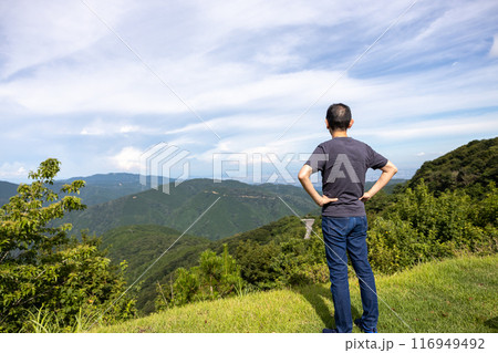 伊吹山に登って腰に手を当てて景色を眺める男性 伊吹山に登って腰に手を当てて景色を眺める男性 116949492