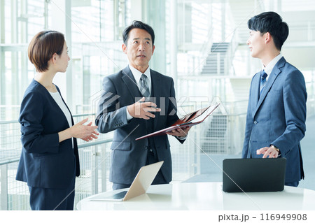 オフィスで立ち話をするビジネスパーソン 116949908