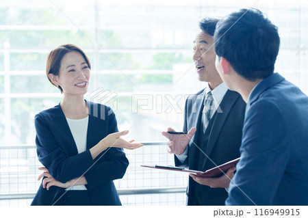 オフィスで立ち話をするビジネスパーソン オフィスで立ち話をするビジネスパーソン 116949915